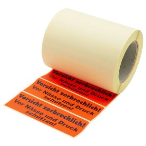 Rolle mit roten Papieretiketten, mit Aufschrift "Vorsicht zerbrechlich! Vor N&auml;sse und Druck sch&uuml;tzen".